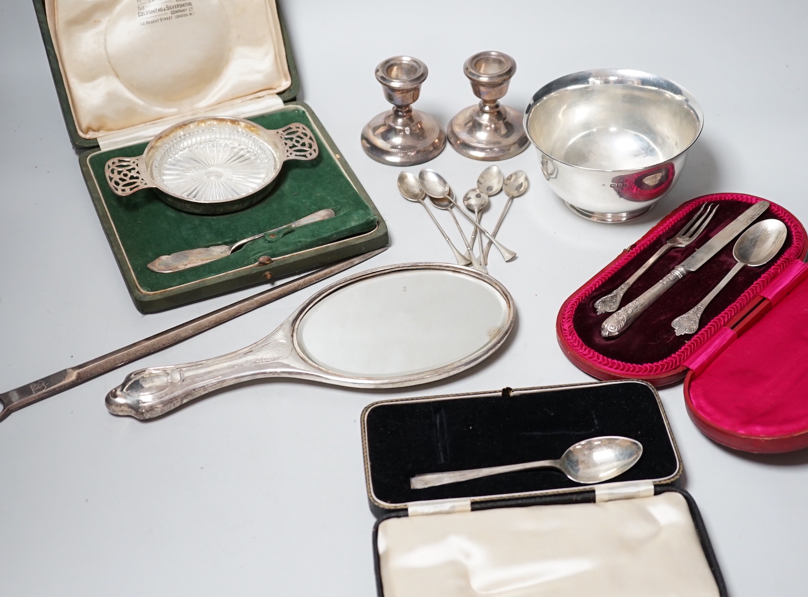 A George IV silver meat skewer, Robert Poulden, London, 1821, 30cm and other sundry silver including a George V bowl, a cased christening trio, pair of dwarf candlesticks, cased butter dish and knife, hand mirror etc.